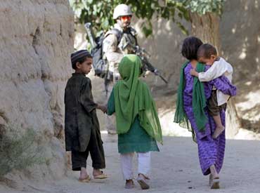Children walk as a Canadian soldier patrols in Nakhonay village in Afghanistan in June 2010