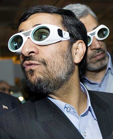 Iran's President Mahmoud Ahmadinejad wears protective glasses while visiting an exhibition of laser science and technology in Tehran