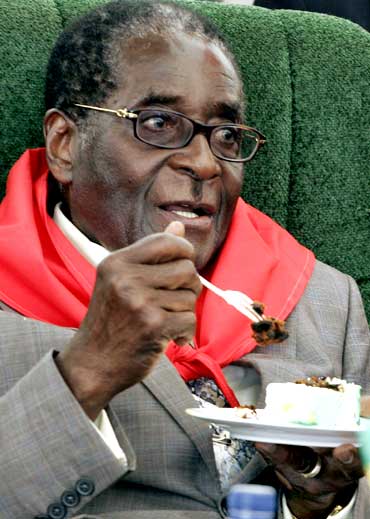 Zimbabwe's President Robert Mugabe eats cake during celebrations for his 85th birthday