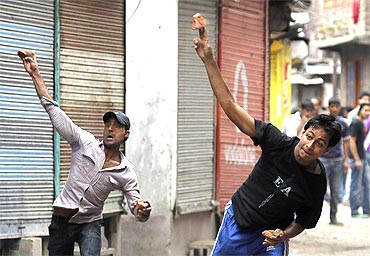 Kashmiri protesters throw stones towards the police during a protest in Srinagar