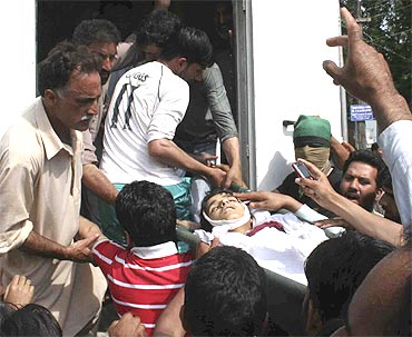 People carry nine-year-old Tariq Ahmad in Baramulla