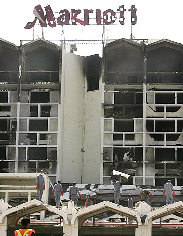 Workers remove debris at the destroyed Marriott hotel in Islamabad