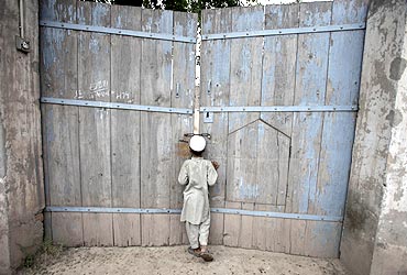 A boy looks through the main gate of the ancestral home of the family of Faisal Shahzad in Pakistan'