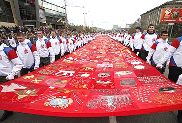 People carry a 44-meter banner made of 516 small flags created in Russia's Siberian settlements