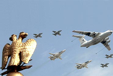 Russian fighters and a flight refuelling tanker fly in formation over the two-headed eagle