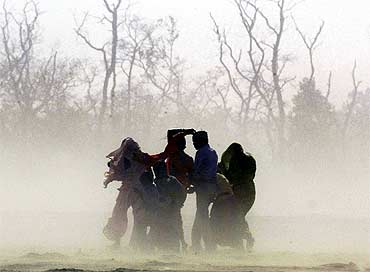 Villagers cover themselves from a sandstorm near India-Nepal border in Pilibhit in Uttar Pradesh