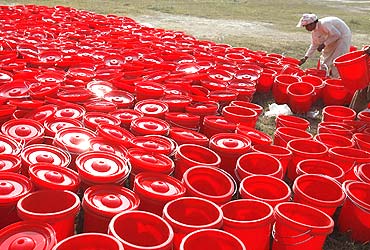 A worker sorts out water-pots at a camp for internally displaced people fleeing the offensive in South Waziristan