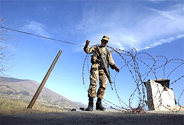 A soldier creates a barrier at a security checkpoint in Swat valley