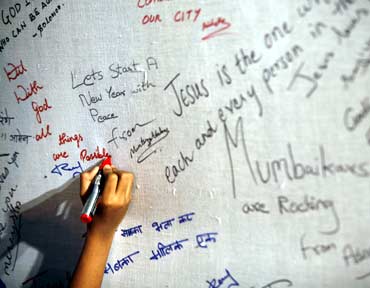 A girl writes a message dedicated to the victims of the Mumbai terror attacks
