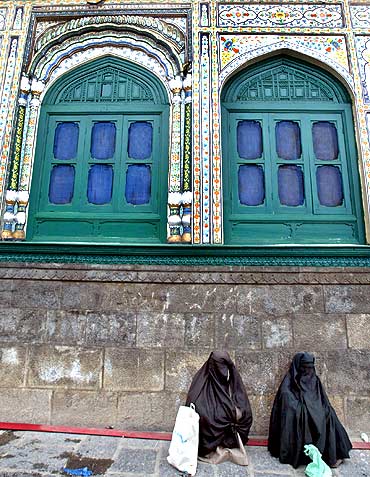 Women beggars wait at a Sufi shrine