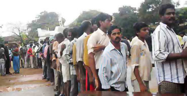 People stand in queue to collect relief materials