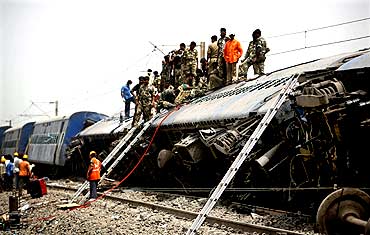 Army troopers and rescue workers conduct rescue operations at the site of the train accident
