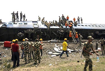 Rescue workers gather near the wreckage of the train