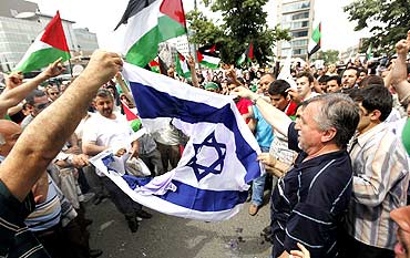Demonstrators try to set afire Israeli flag during a protest near the Israeli Consulate in Istanbul