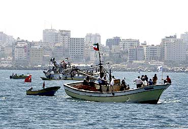 Palestinians ride aboard boats in a preparation for the arrival of a convoy of ships to Gaza's port