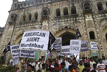 Demonstrators hold placards as they participate in a protest against US President Obama' visit to India, in Lucknow