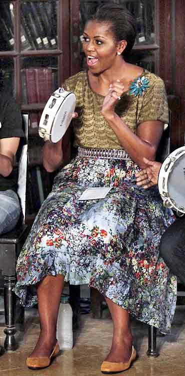 Michelle Obama plays a tambourine for the children
