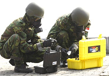 Singapore army personnel in gas masks as part of a drill for the Proliferation Security Initiative Exercise in Japan