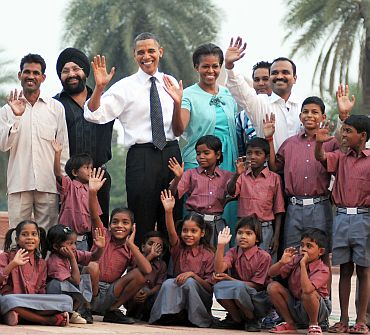 US President Barack Obama and the First Lady Michelle Obama pose for a photo with the school children of traditional artisans who carried out renovation works at Humayun Tomb