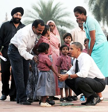 US President Barack Obama and the First Lady Michelle Obama interacting with the school children of traditional artisans who carried out renovation works at Humayun Tomb
