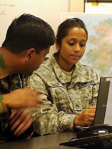 Cpl Balreet Kaur, a medic for the 79th Infantry Brigade Combat Team (California National Guard), discusses exercise communication procedures with an Indian Army soldier