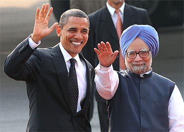 US President Obama and Indian PM Dr Singh wave after Obama arrived at New Delhi's airport