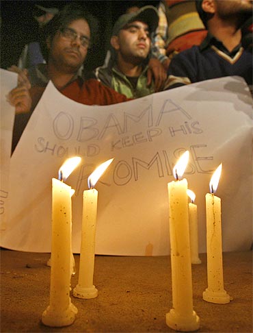 Students of Kashmir University hold a placard behind burning candles to highlight the 'Kashmir issue', during Obama's visit