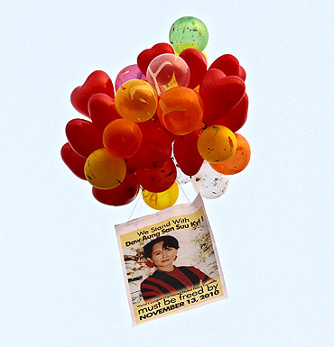 A portrait of Suu Kyi and balloons are released by her supporters during celebrations after her release