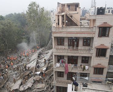 Rescue workers search for survivors under the rubble of a collapsed
