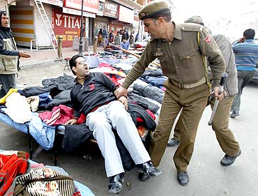 Policemen confront a demonstrator after a protest in Srinagar