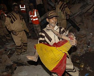 A rescue worker carries an injured girl to safety