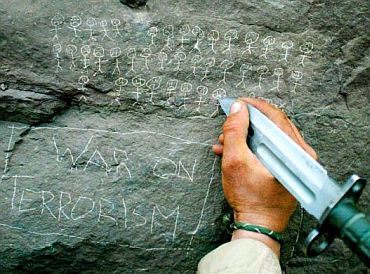 A US Army 10th Mountain Division soldier from Miami, Florida carves the body count that their mortar team has chalked up on a rock, near the villages of Sherkhankheyl, Marzak and Bobelkiel, March 9, 2002