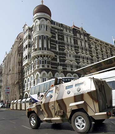 A police armoured car patrols outside the Taj Hotel