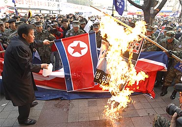 Protesters burn North Korean flags and portraits of North Korean leaders in Seoul
