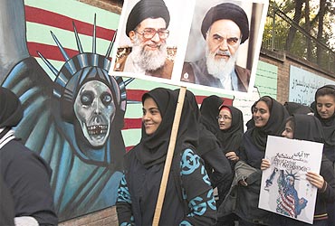 Students take part in a demonstration as one of them holds pictures of Iran's Supreme Leader Ayatollah Ali Khamenei