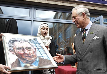 Britain's Prince Charles is presented with a portrait of himself