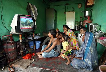 A family watches a TV news channel in a room in Ayodhya on Thursday