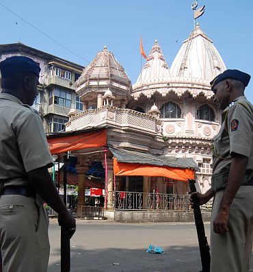 Policemen stand guard in front of a temple in Mumbai on Thursday