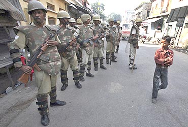 A boy walks past paramilitary troopers in Ayodhya