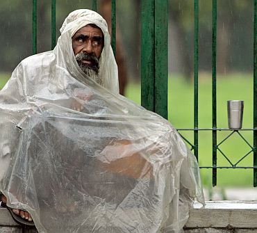 File photo shows a beggar covers himself with a polythene sheet on a street in New Delhi