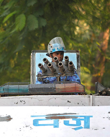 A security personnel keeps guard atop his armoured vehicle outside the high court in Lucknow