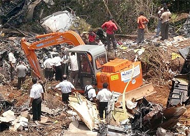 Rescuers try to dig out bodies from the crash debris following the mishap in Mangalore
