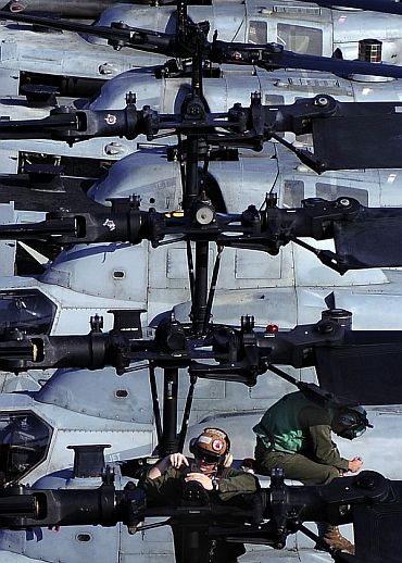 Maintenance work being done on the rotor of an AH-1Z Super Cobra helicopter aboard USS Essex