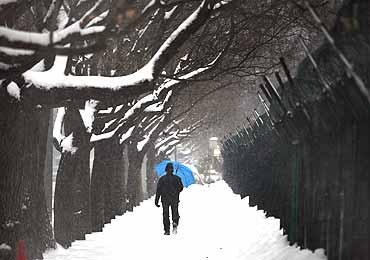 A man walks along a icy footpath