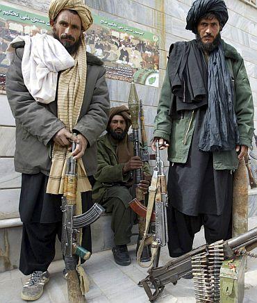 Taliban militants pose for pictures after they join reconciliation program with the Afghan government, in Herat