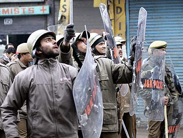 Policemen with protective shields at a protest in Kashmir