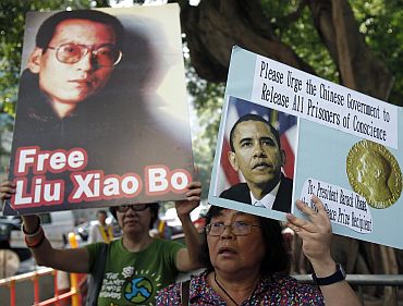A demonstrator holds a picture of Chinese dissident Liu Xiaobo during a protest, urging Nobel peace prize recipient and US President Barack Obama to demand the Chinese government to release all dissidents, outside the US Consulate General in Hong Kong