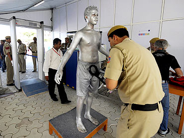 An artist goes through a security check before his performance at the Commonwealth Games athletes Village in New Delhi