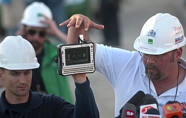 Engineer Ben Morris (Left) of the US and Chilean medical doctor Jean Romagnoli show journalists a gauge that will be used to monitor the vital signs of the trapped miners as they are lifted individually to the surface in a capsule