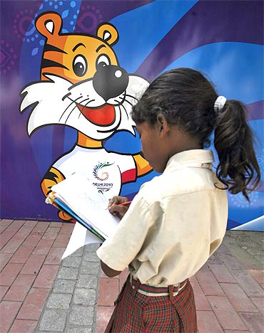 A schoolgirl makes a drawing of the mascot of the Commonwealth Games